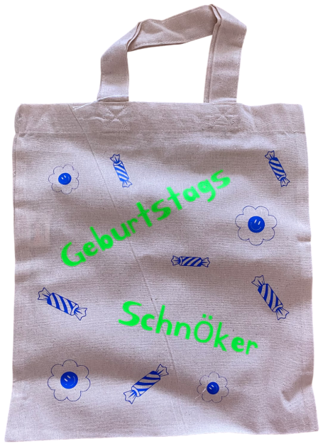 Beige Stofftasche mit grüner und blauer Aufschrift "Geburtstags Schnöker".