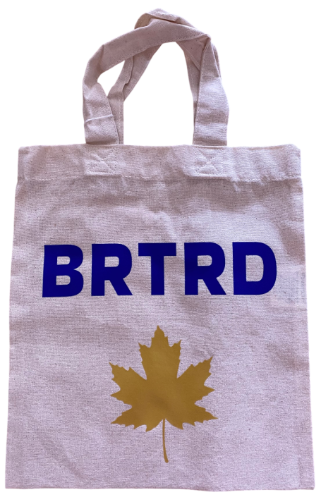 Weiße Tragetasche mit blauer Aufschrift "BRTRD" und goldenem Ahornblatt.