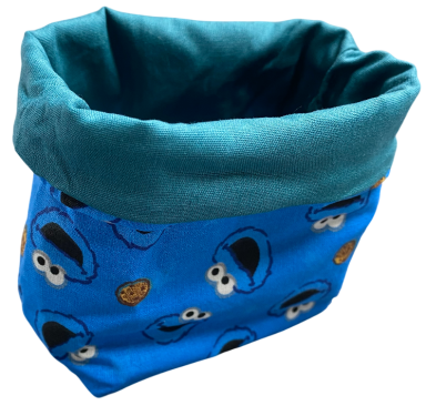 Blauer Aufbewahrungskorb mit Keks-Monster-Motiv und grünem Innenfutter.