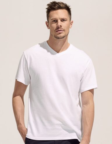 Mann trägt ein schlichtes, weißes T-Shirt und schaut direkt in die Kamera.