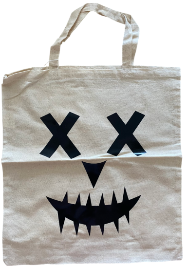 Beige Baumwolltasche mit schwarzem, grinsendem Gesicht und kreuzförmigen Augen.