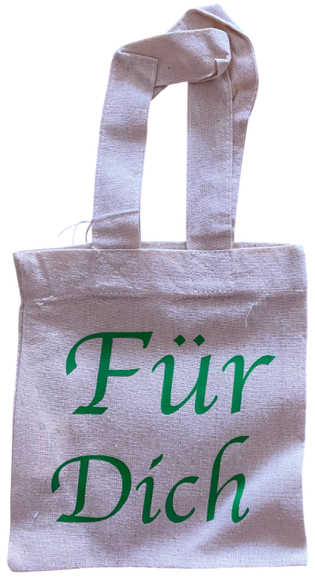 Beige Stofftasche mit dem grünen Text „Für Dich“.