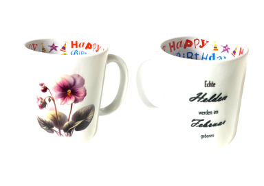 Weiße Tasse mit blühender Blume und buntem, fröhlichem Schriftzug innen.