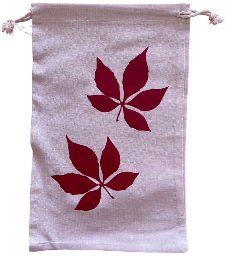 Beige Tasche mit roten Blattmotiven.