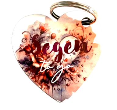 Herzanhänger mit floralem Muster und dem Schriftzug „Segen to go“.