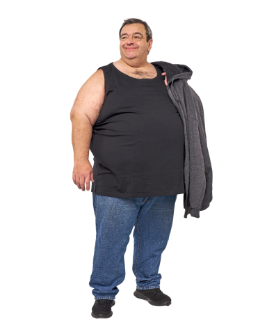 Mann in ärmellosem Shirt und Jeans, hält eine graue Jacke in der Hand.