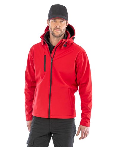 Mann in roter Jacke und schwarzem Cap, lächelnd mit neutralem Hintergrund.
