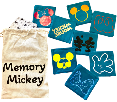 Bunte Memory-Spielkarten mit Disney-Mickey-Motiven in einem Sack.