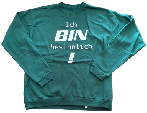 Grüner Pullover mit Aufdruck: "Ich BIN besinnlich!" in großen, weißen Buchstaben.