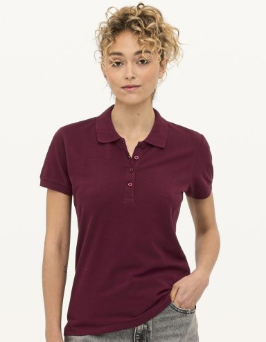 Junge Frau trägt ein weinrotes Polohemd und schaut direkt in die Kamera.