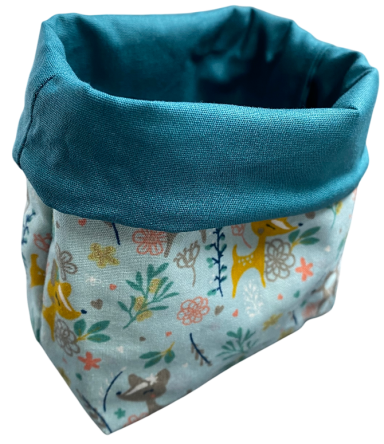 Hochformatiges Aufbewahrungskörbchen mit buntem Pflanzenmuster und blauem Rand.