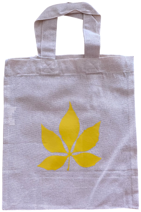 Eine helle Tasche mit einem gelben Blattmuster.